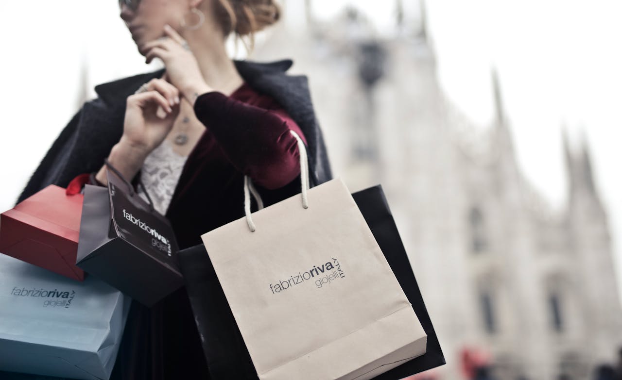 Stylish woman holding designer shopping bags near Milans iconic Duomo. Urban fashion and lifestyle concept.